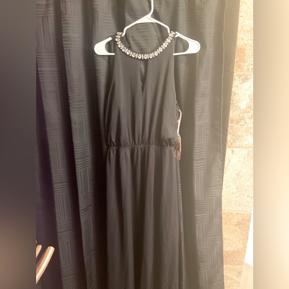 Black dress with rhinestones around the neck.